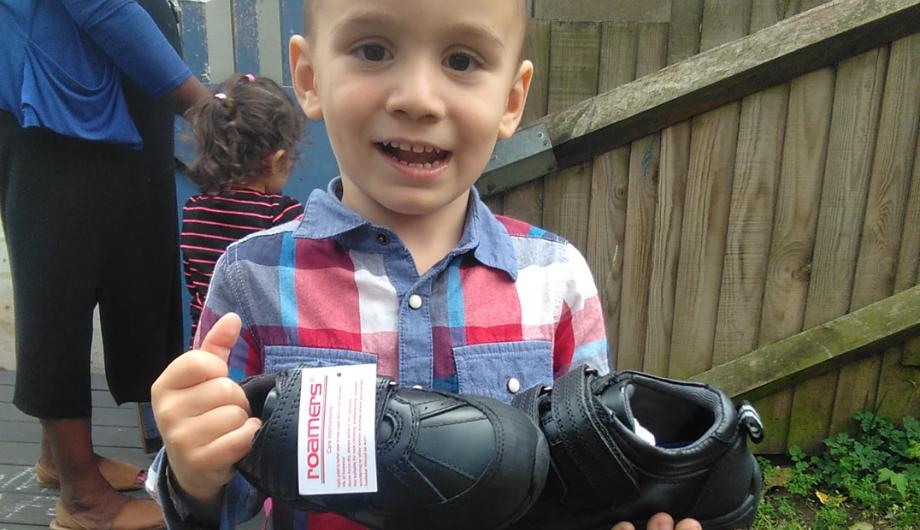 Child at the nursery showing their new pair of school schools donated by Sal Shoes