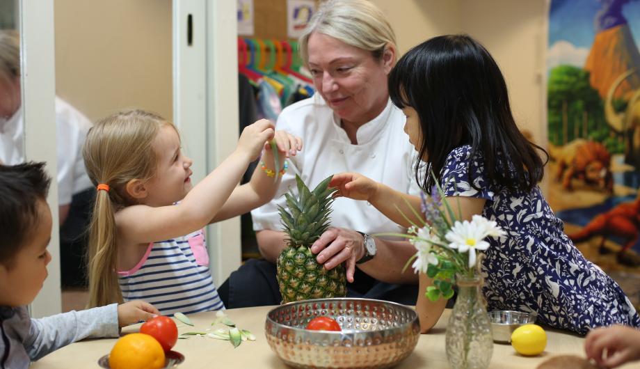 Children exploring different fruits with the nursery chef