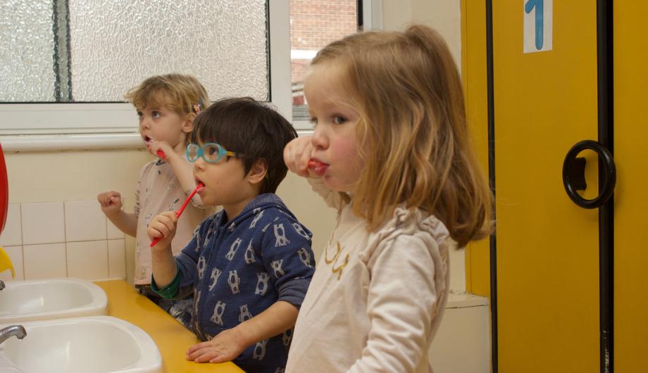 Children practicing how to brush their teeth after lunch